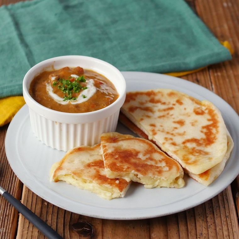 電子レンジで加熱し発酵なしで作ったチーズナンとカレーが皿に盛り付けられているところ