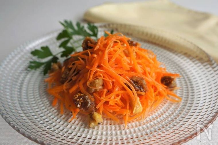 ガラスの器に盛り付けられたいちじくとくるみのキャロットラペ