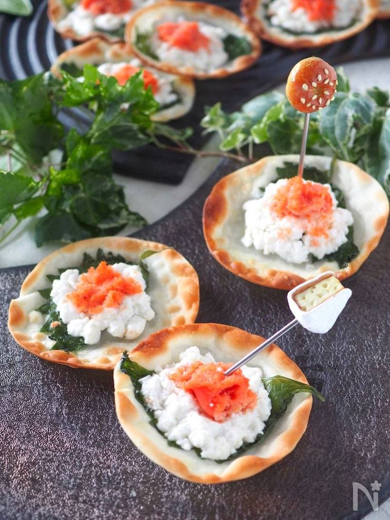 黒い器に並べられた3個の明太子とチーズのパリパリ焼き