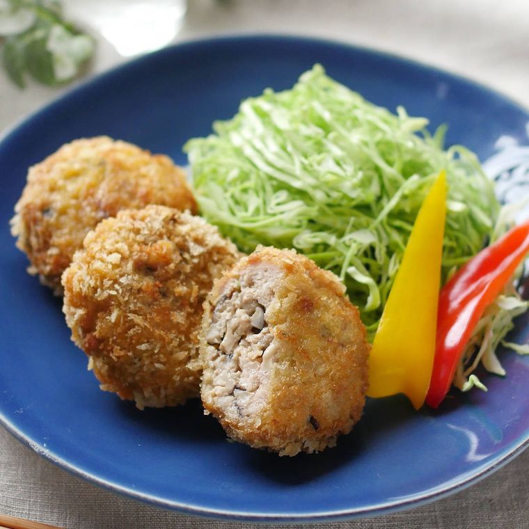 青色の丸皿に盛られたたっぷりきのこのメンチカツ