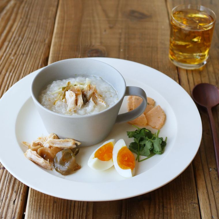 カップに入っている中華粥とトッピングを盛り付けたワンプレート