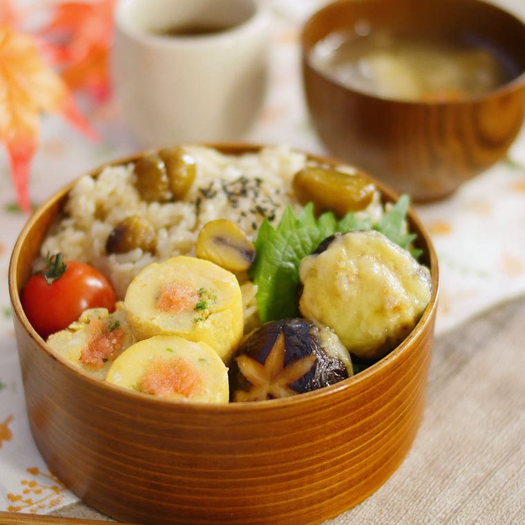 曲げわっぱの弁当箱に入った栗ごはんと、ねぎ明太卵焼き、しいたけの肉味噌焼き、ミニトマト