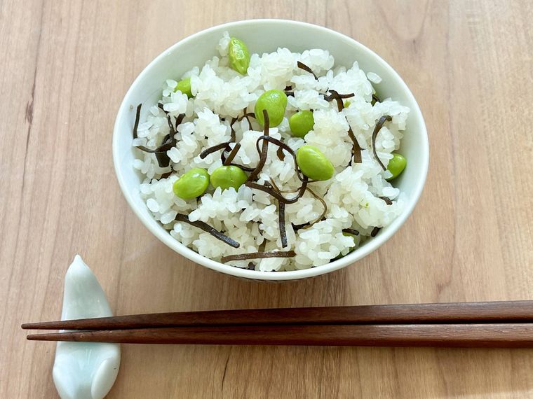 炊飯器で作った枝豆と塩こんぶの炊き込みごはんがご飯茶碗に盛り付けられているところ