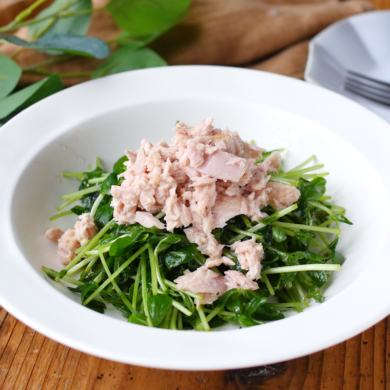 白い皿に盛られた豆苗とツナのオリーブオイルサラダ