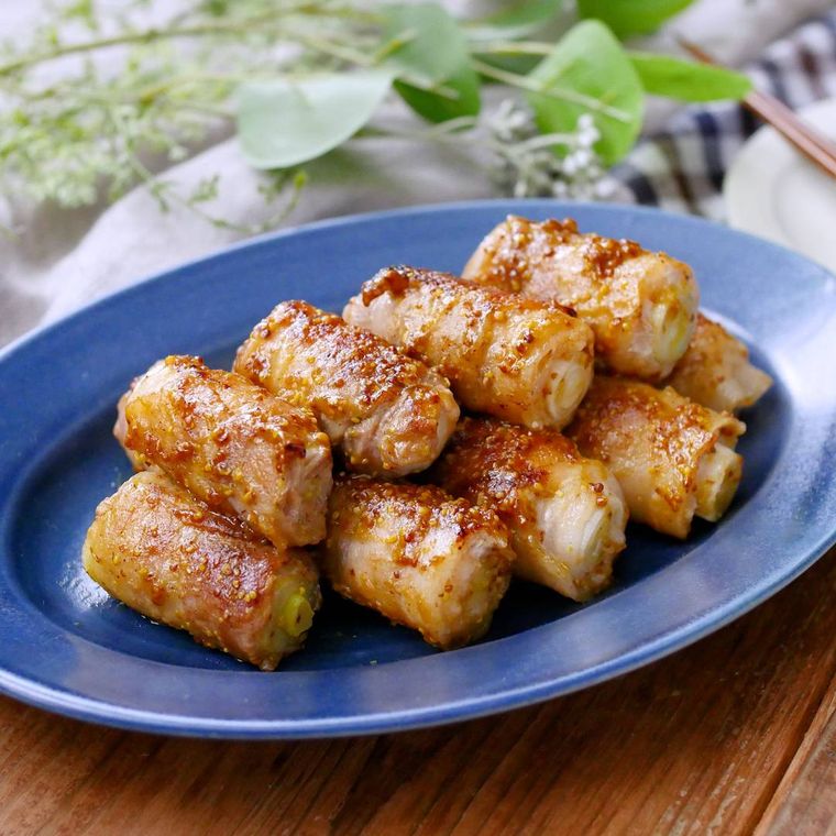 青い皿にきれいに並べて盛りつけられた長ねぎと豚肉のマスタード炒め