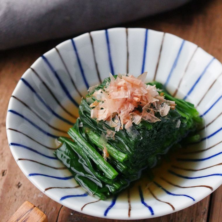 青色と茶色の縦縞が入った器に盛られたほうれん草のおひたし