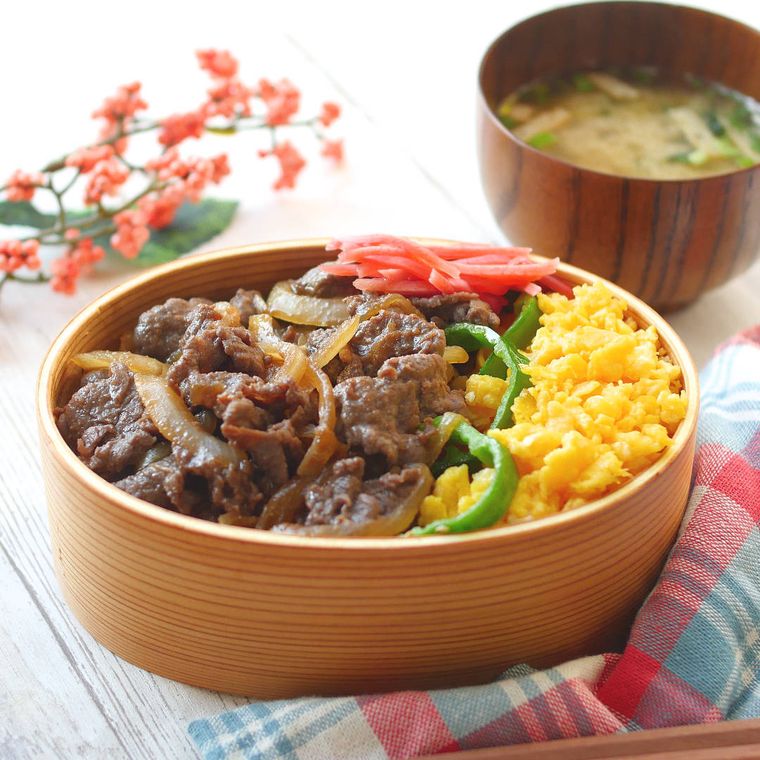 炒り卵とともに曲げわっぱの弁当箱に盛り付けられた牛丼弁当