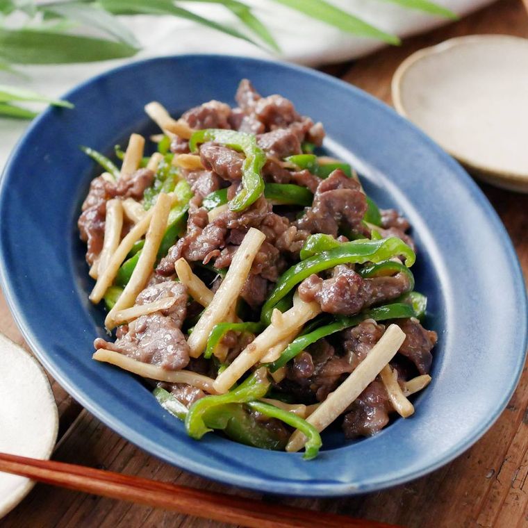 青い楕円型の皿に盛り付けた牛肉とピーマンの細切り炒め