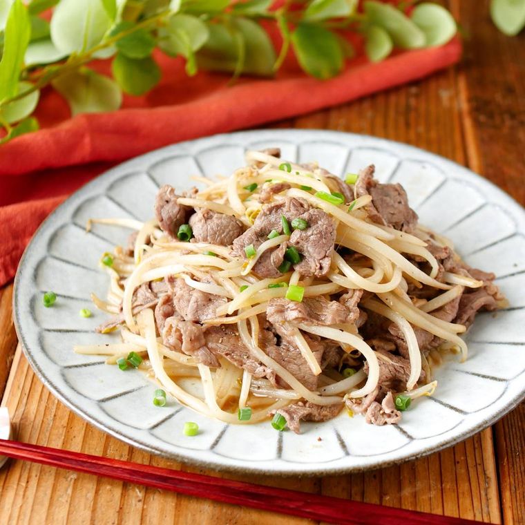 白い丸皿に盛り付けた牛肉ともやしのポン酢しょうゆ炒め