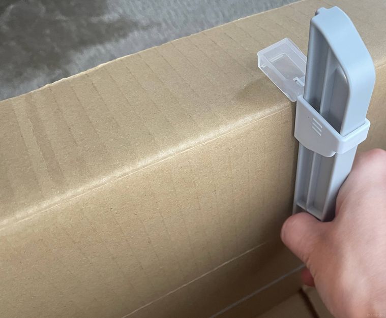 段ボールサイズ調整カッターを段ボールに当てている様子