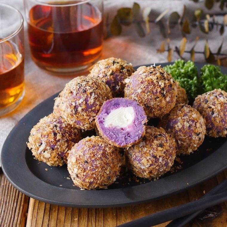 黒い皿に盛り付けられたさつまいもコロッケ