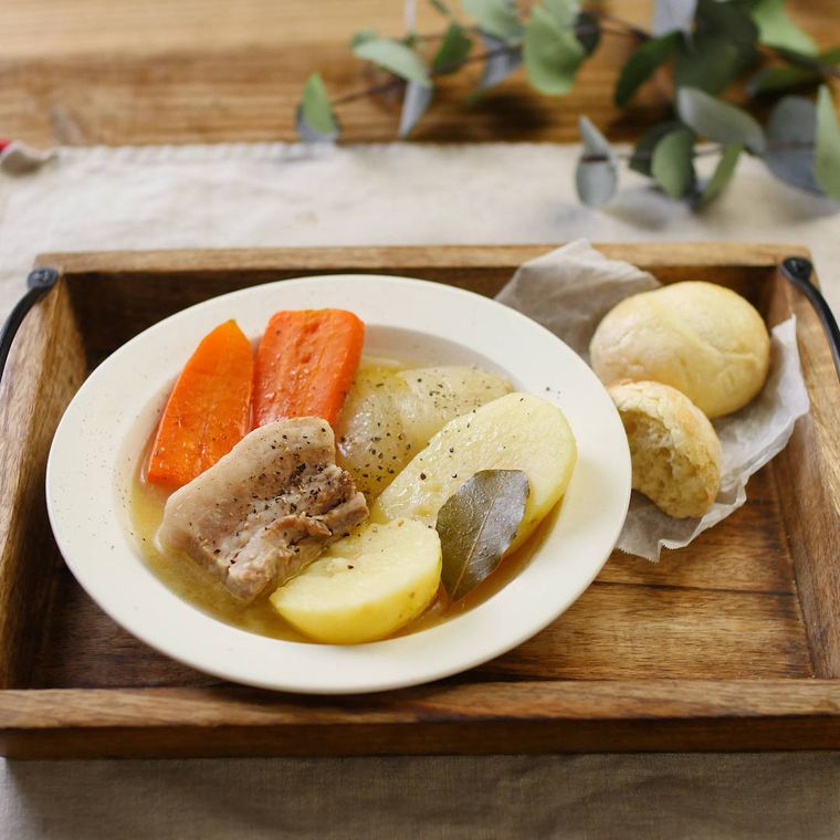 白いシチュー皿に盛り付けられている豚バラかたまり肉のシンプルポトフ