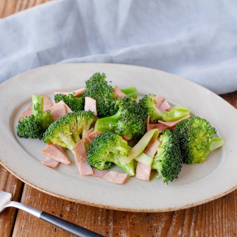 薄いグレーの皿に盛り付けられたブロッコリーとハムのソテー