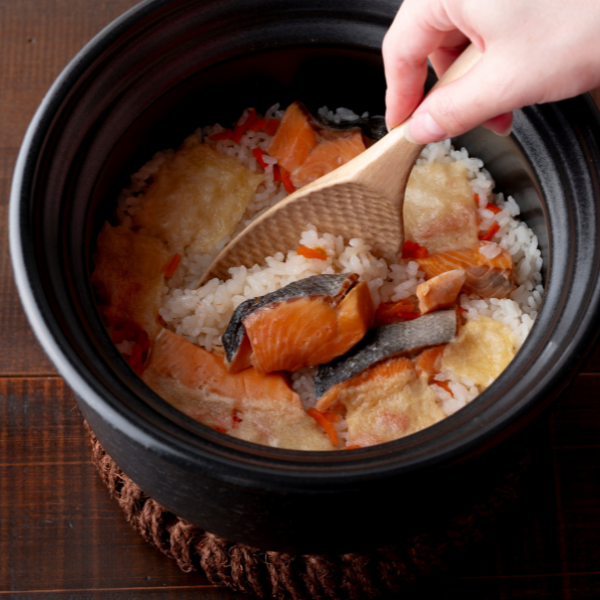 釜の中の炊き込みごはんをしゃもじで混ぜているところ
