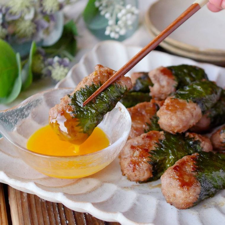 溶き卵に大葉棒つくねをつけている様子