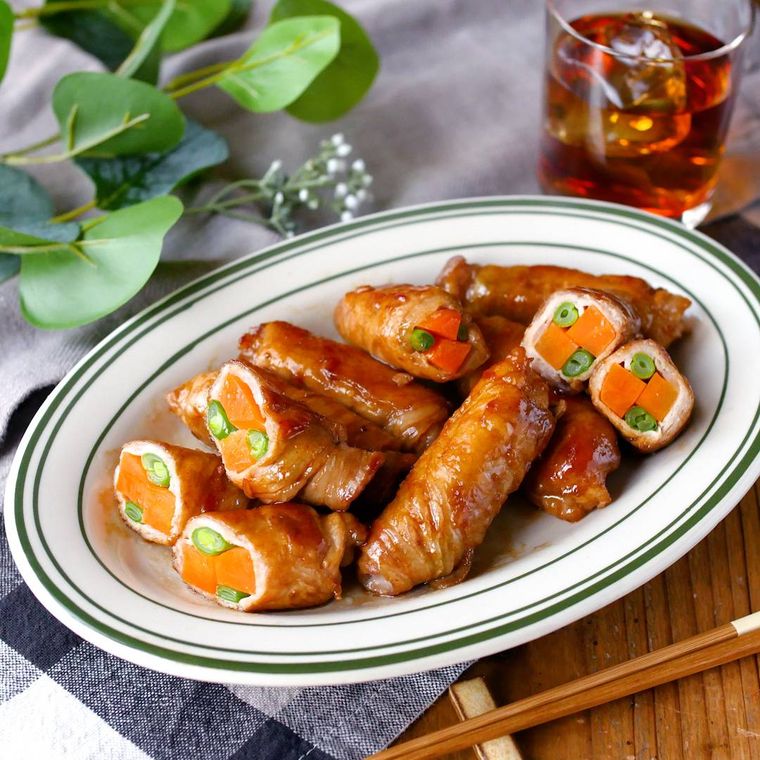 緑と白の皿に入ったいんげんとにんじんの肉巻き