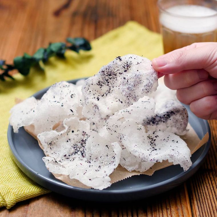 黒色の丸皿に盛られたゆかりチーズライスペーパーチップス