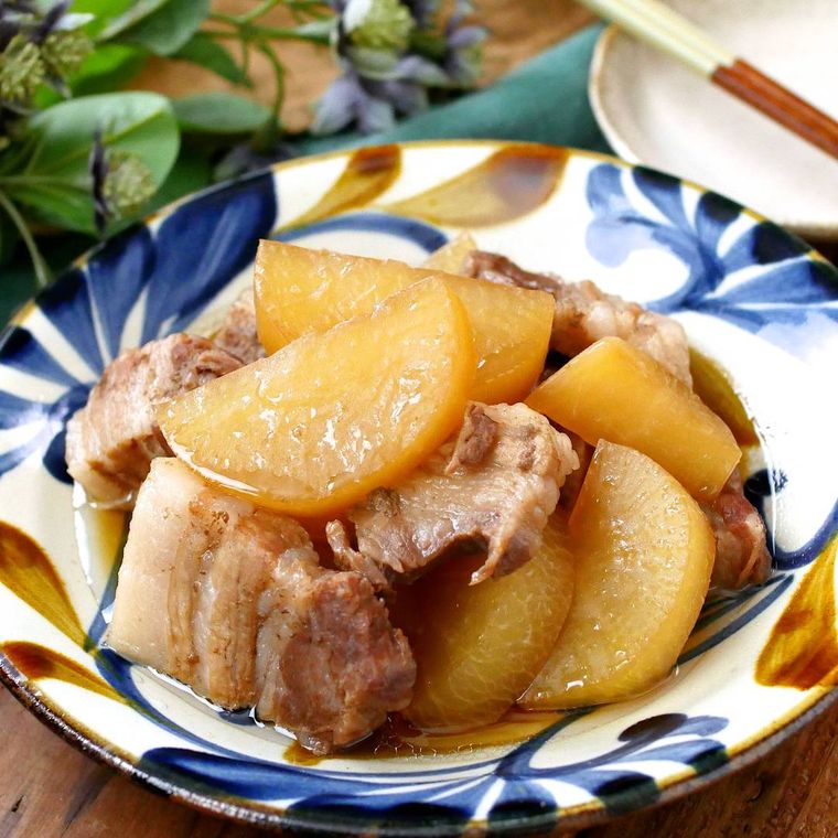 青色と茶色の模様が入った白色の皿に盛られた炊飯器で豚バラ大根