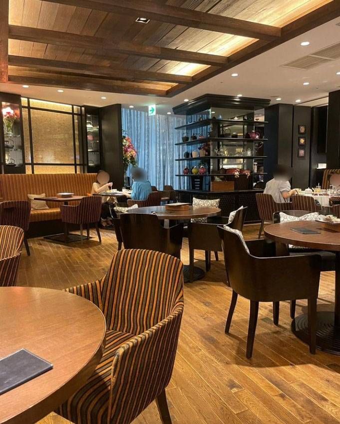 シックな内装のなかにテーブル席が並ぶダマンリュミエール 高島屋大阪店の店内