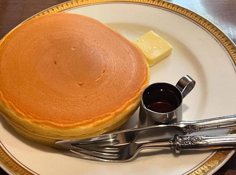 白いお皿に盛られた ホットケーキメープルorはちみつとナイフ、フォーク