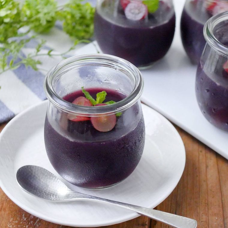 ガラスの器に盛られ、ミントをトッピングしたブドウジュースのゼリー