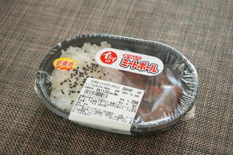 茶色いランチョンマットとミートボールとパスタとごまごはんのコンビニ弁当