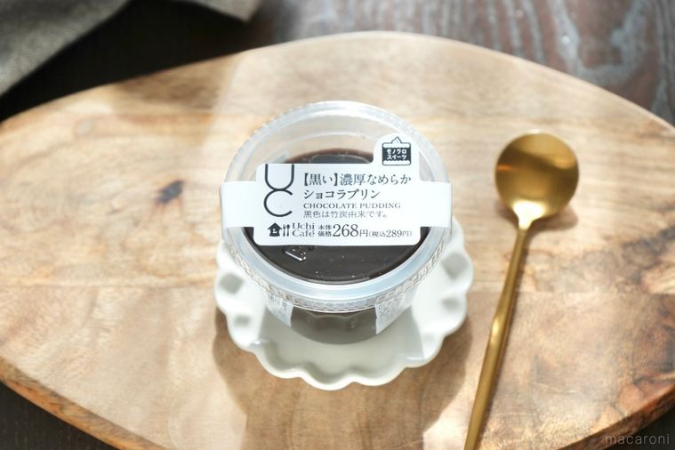 木のカッティングボードと白い小皿にのった黒いショコラプリンと金のスプーン