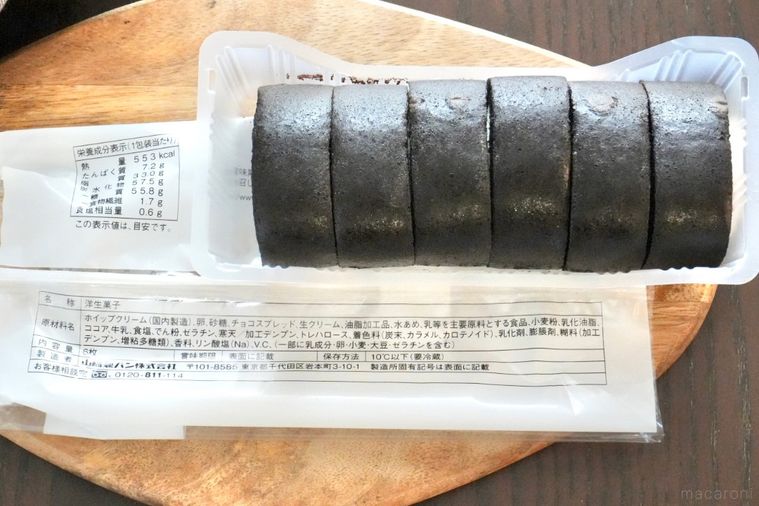 木のカッティングボードにのった真っ黒なもち食感ロールと成分表示