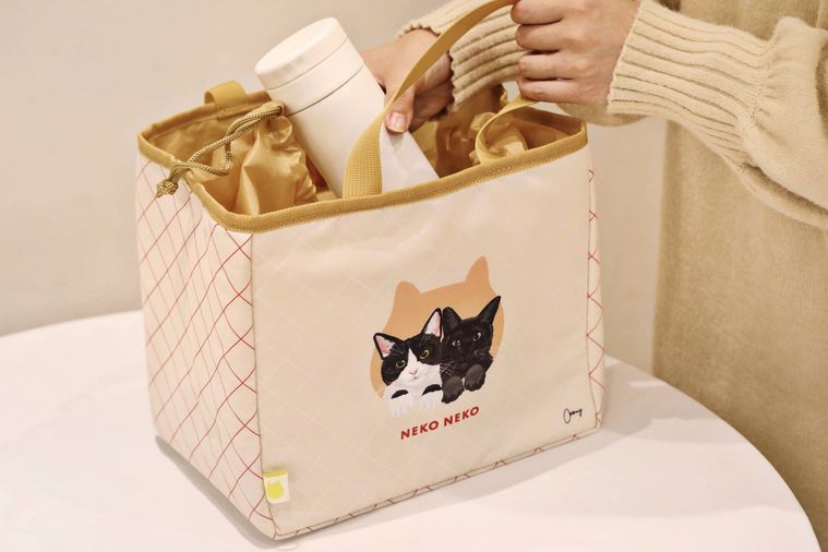 ねこねこランチ保冷バッグはちわれと黒ねこに水筒を入れている様子