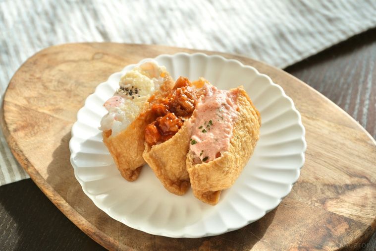 木のカッティングボードと白い皿にのった韓国風いなりのユブチョバプ