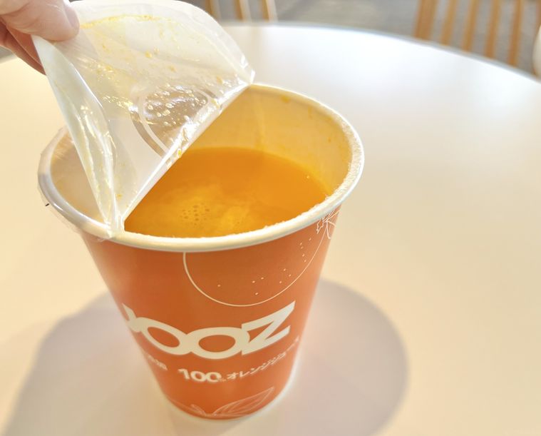 オレンジジュースのフタを開けている様子