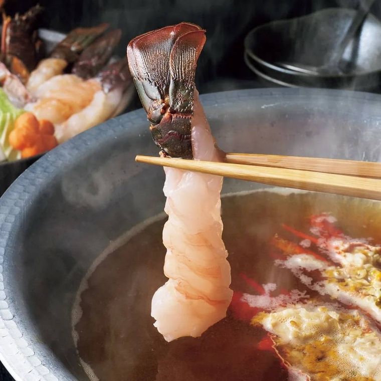 伊勢海老をだしにくぐらせようとしている様子