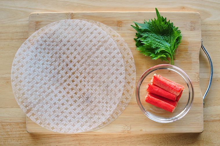 まな板の上にライスペーパーとカニカマ、大葉がのせてある