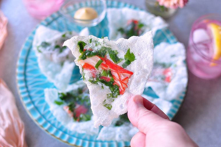 カニカマ入りライスペーパーチップスを手に持つ様子