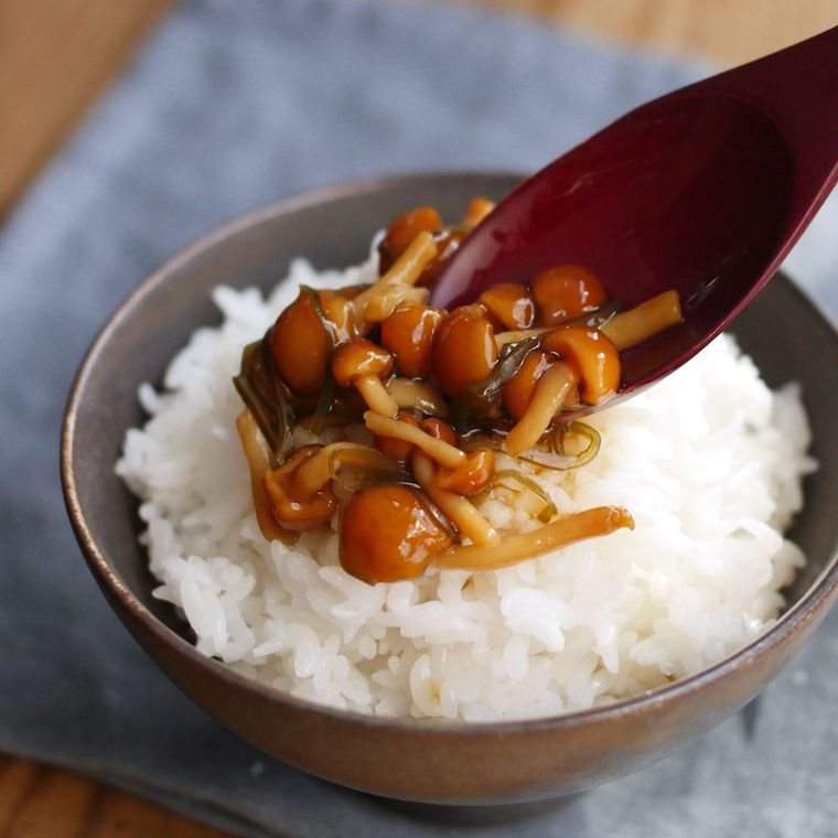 茶碗に盛られたごはんになめたけなめこを盛る様子