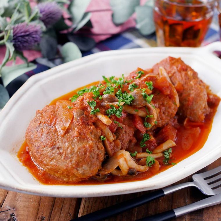 赤色の煮込みハンバーグがたっぷり盛られている皿