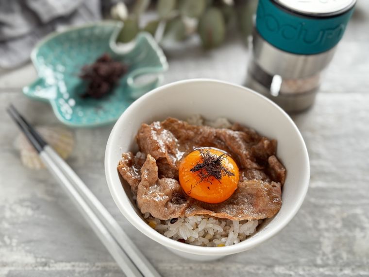 白いどんぶりに入った牛丼と卵黄にトリュフ海藻がトッピングされた様子