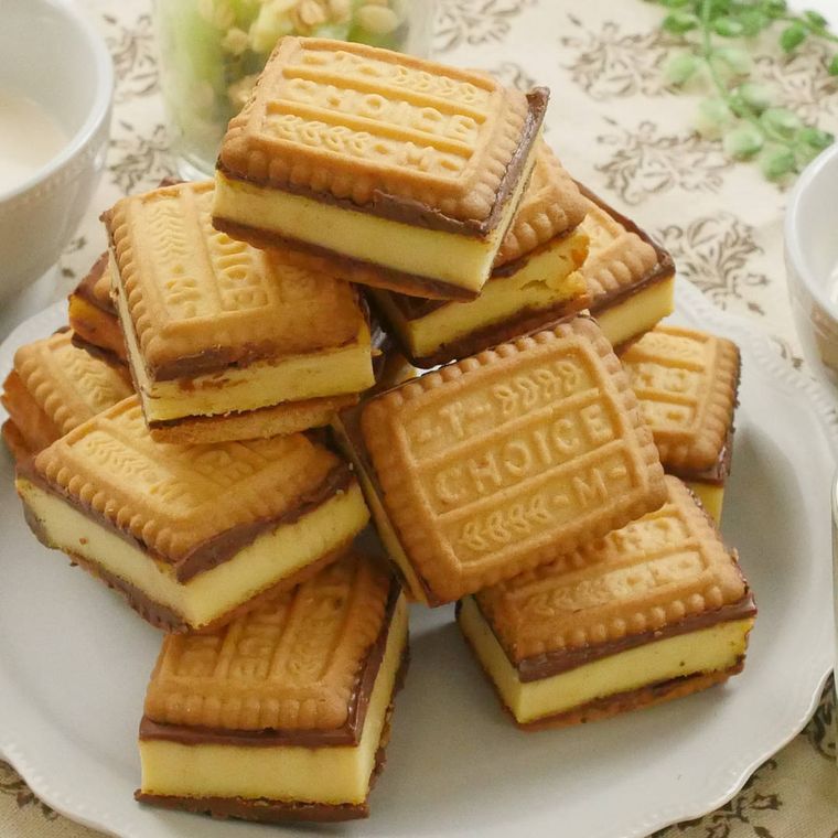 ベージュの皿にのせた山盛りの塩キャラメルチーズケーキのクッキーサンドを