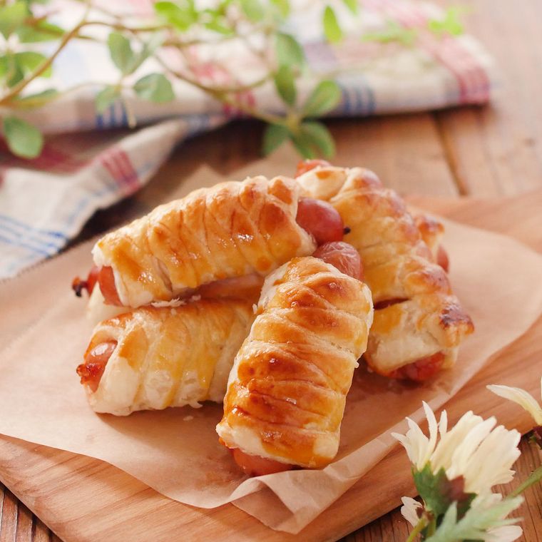 木のトレーにのせた編み込みソーセージパイ