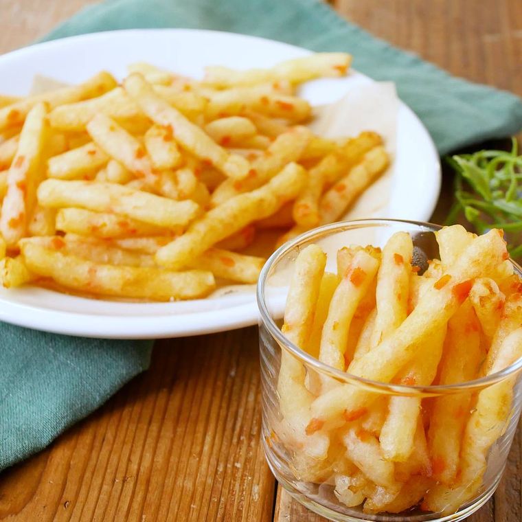 白い皿とガラスのコップに入ったじゃがいもスティック