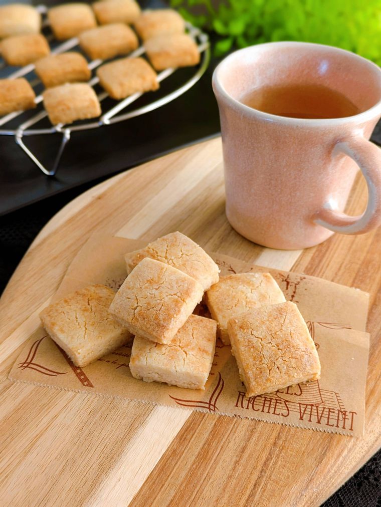 カッティングボードに盛り付けたクッキーと紅茶の入ったカップ