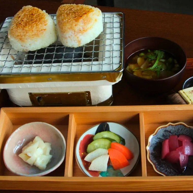 網にのった焼きおにぎり2個と漬もの3種、汁ものが付いたお膳