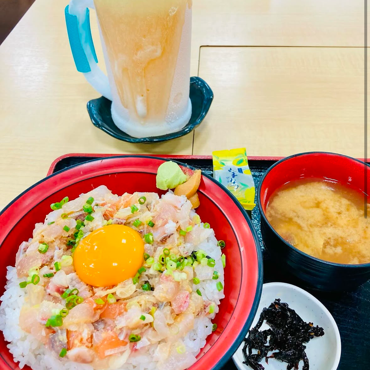 新鮮な海鮮をたっぷり使った丼。ごはんの上に細かく刻まれたなめろうが敷き詰め、みそ汁と漬物が付く