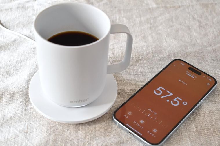 専用コースターに置いたマグカップとスマートフォンのアプリ画面