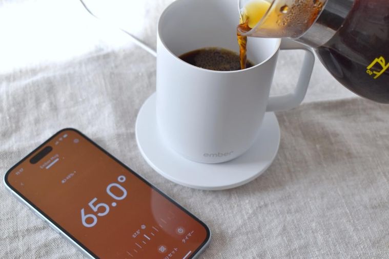 コーヒーを注いだマグカップと専用アプリ画面