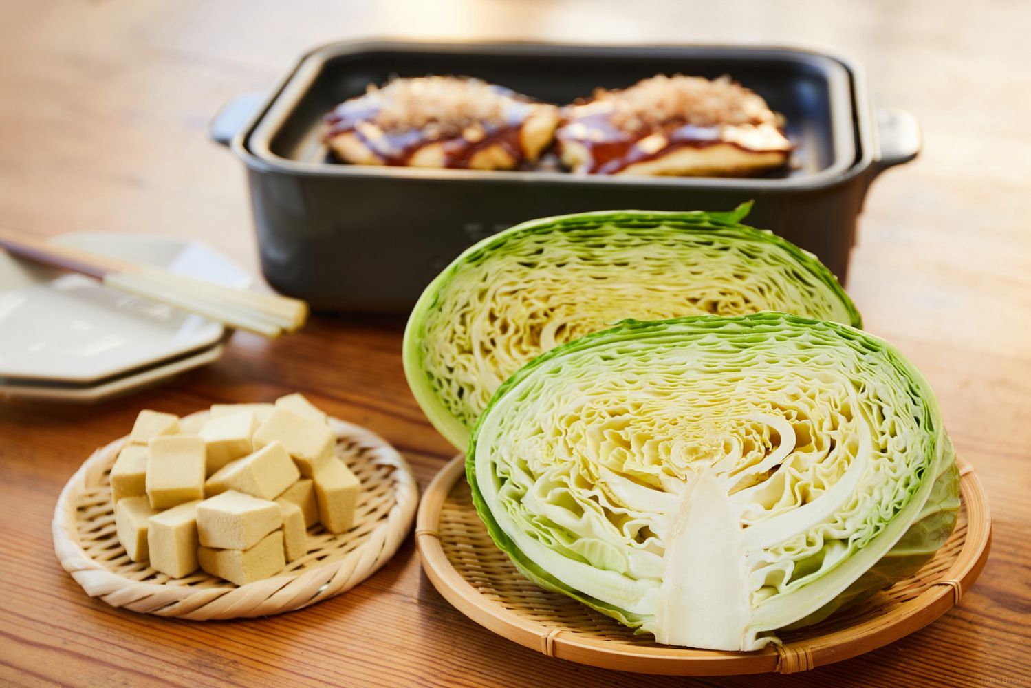 テーブルにお好み焼きとキャベツと高野豆腐が置かれている