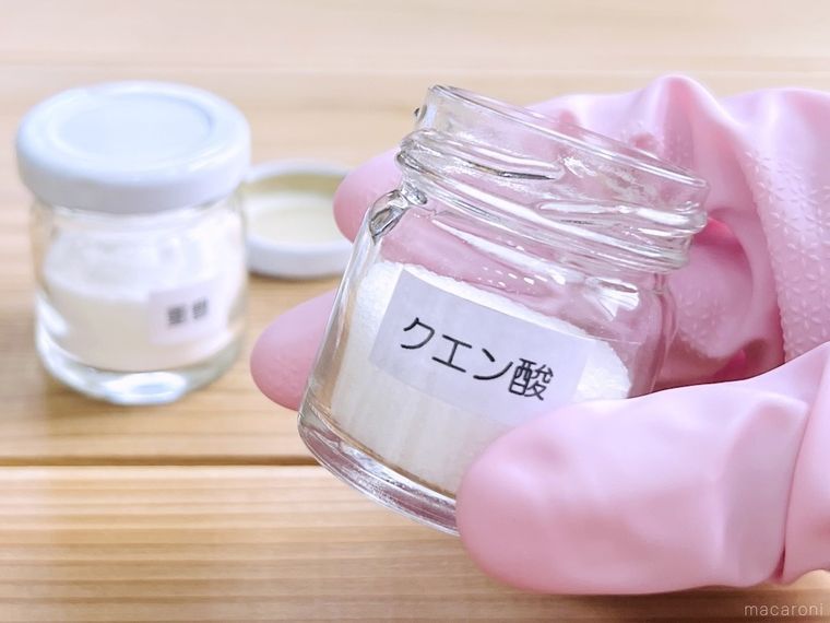 瓶に入ったクエン酸を手で持っている様子