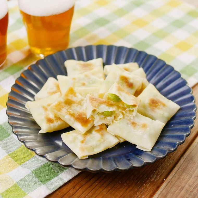 紺色の花型の皿に盛り付けた枝豆チーズのパリパリ焼き