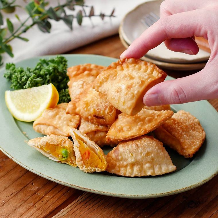 薄緑色の楕円型の皿に盛り付けたかぼちゃのサモサ風