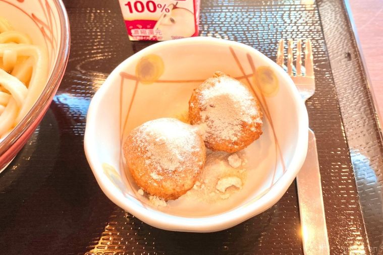 黒いお盆と白い器にのったドーナツとジュース